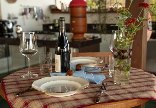 a table with a plate and a bottle of wine at Pariká Pousada in Alto Paraíso de Goiás