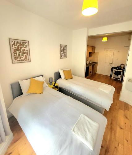 a room with two beds and a kitchen at London En-suite Double Rooms - Leytonstone E11 in London