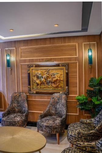 a room with two chairs and a painting on the wall at Hotel Arabesque in Rabat