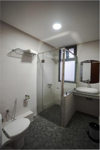 a bathroom with a shower and a toilet and a sink at Hotel Arabesque in Rabat