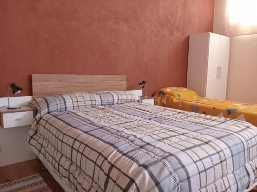 a bedroom with a bed with a plaid blanket at Alojamiento Práctico y acogedor in Zapala