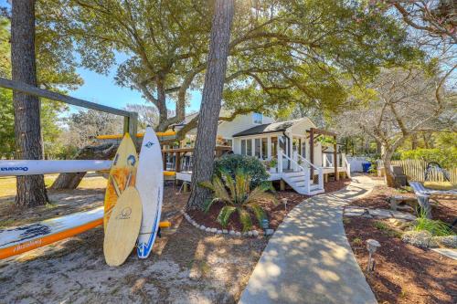 a house with two surfboards in front of a playground at Waterfront Pine Knoll Shores Gem with Boat Dock in Pine Knoll Shores