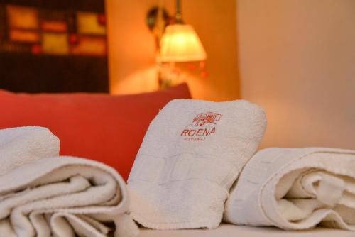 a pile of towels on top of a bed at Roena Cabañas in Villa Giardino