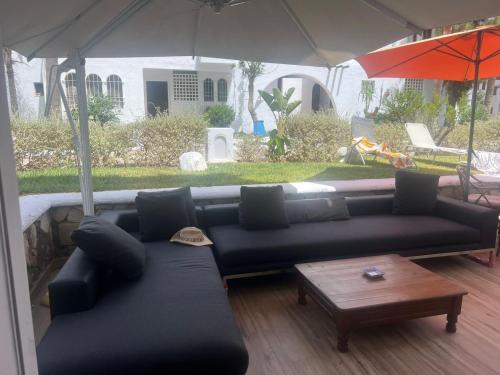 a living room with a black couch and an umbrella at Bahia Smir in Restinga Smir
