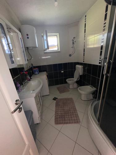 ein Badezimmer mit zwei Toiletten und einem Waschbecken in der Unterkunft Apartment Panonija in Tuzla