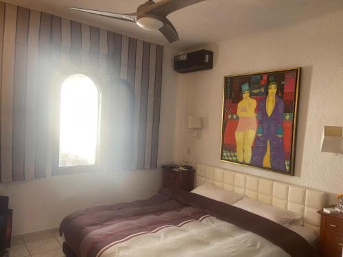 una camera da letto con un letto e un quadro sul muro di Bahia Smir a Dar Merah Deriba