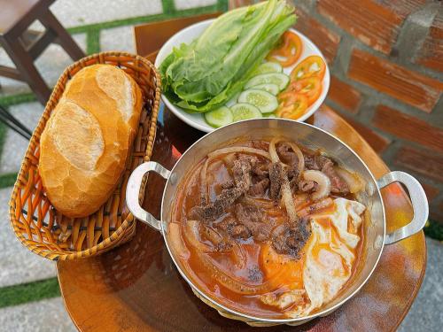 a pot of soup with a sandwich and a plate of food at Kara Homestay & Cafe in Can Tho