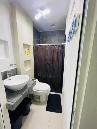 a bathroom with a toilet and a sink at Casa Azul in Isla Mujeres