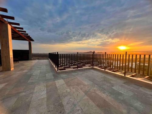 a view of a deck with the sunset in the background at Penthouse with panoramic terrace and pool in San José del Cabo