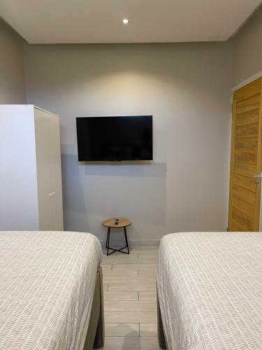 a room with two beds and a flat screen tv at Boa vista appartementen in Paramaribo