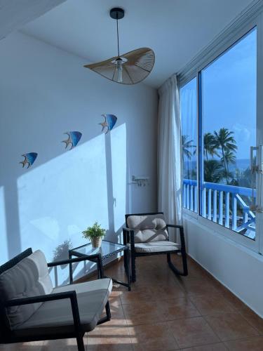a living room with a couch and a large window at Apartamento l Vista al Mar Albatros BY JU Juan Dolio in Juan Dolio