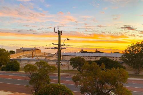 an empty road with a sunset in the background at Sunsets on Hampton, Fremantle WA in Fremantle
