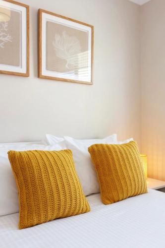 a bed with two yellow pillows on top of it at Sunsets on Hampton, Fremantle WA in Fremantle