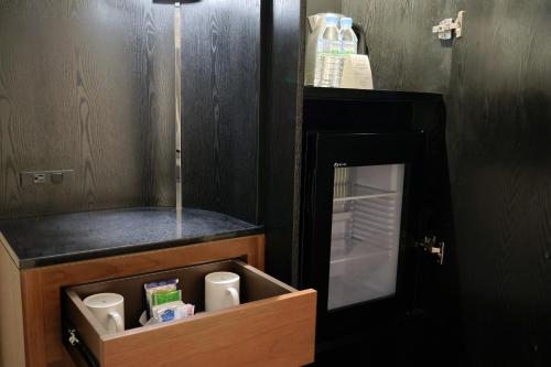 a small refrigerator with a drawer with cups in it at Hilton Guam Resort & Spa in Tumon