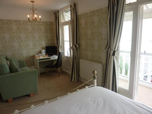 1 dormitorio con 1 cama y escritorio con ordenador en Pebbles Guest House en Southend-on-Sea