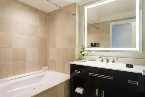 a bathroom with a tub and a sink and a mirror at The Ritz-Carlton, Philadelphia in Philadelphia