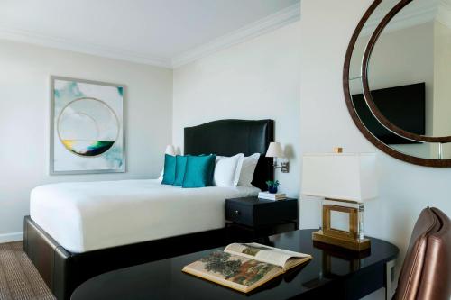 a bedroom with a bed and a table with a mirror at The Ritz-Carlton, Philadelphia in Philadelphia