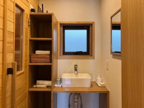 a bathroom with a sink and a window at MY LODGE Naoshima in Naoshima