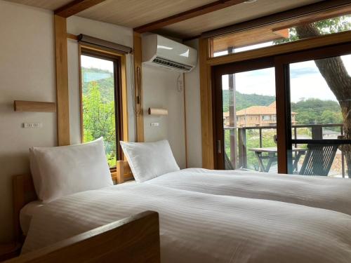 a bedroom with a large white bed and a window at MY LODGE Naoshima in Naoshima