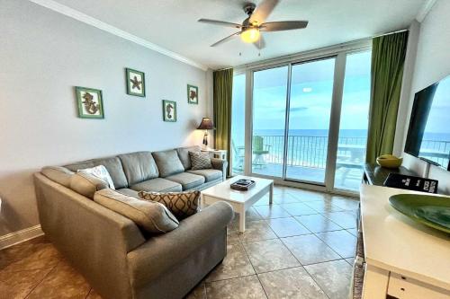 a living room with a couch and a view of the ocean at Lighthouse 1017 Condo in Gulf Shores