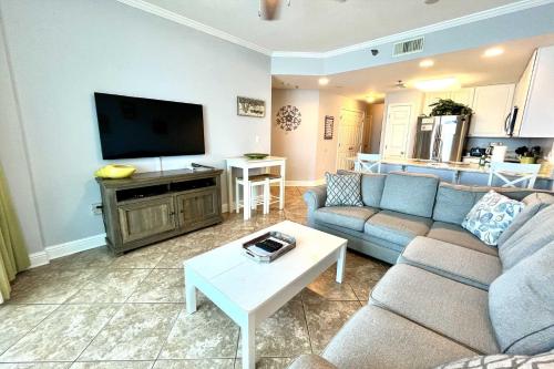 a living room with a couch and a flat screen tv at Lighthouse 1017 Condo in Gulf Shores