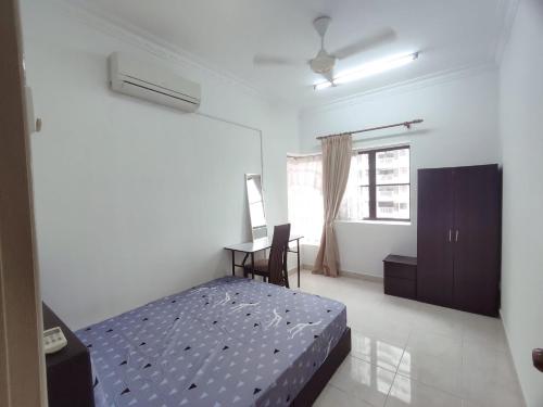 a bedroom with a bed and a desk in it at SS GREY HOMESTAY Pelangi Utama in Petaling Jaya