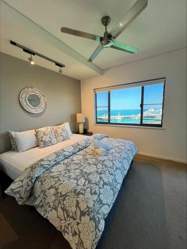 a bedroom with a bed and a ceiling fan at Sea Pearl Apartment at Waterfront in Darwin