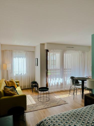 a living room with a couch and a table at Appartement avec balcon centre ville Strasbourg in Strasbourg