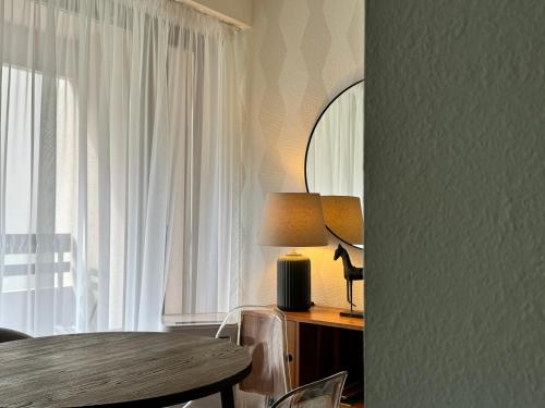 a room with a table with a lamp and a window at Appartement avec balcon centre ville Strasbourg in Strasbourg