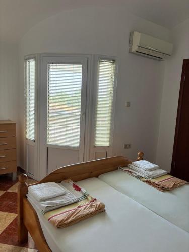 two twin beds in a room with windows at Apartments Katarina in Bar