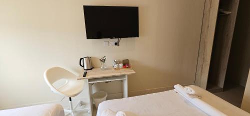 a room with a bed and a table with a tv on the wall at MSM Arena Hotel in London