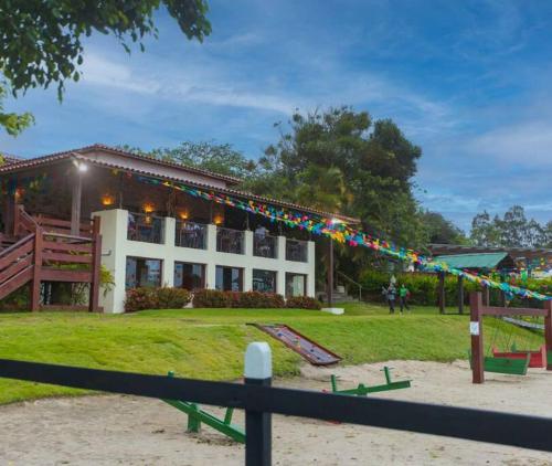 a building with a playground in front of it at Flat Fazenda Monte Castelo in Bezerros