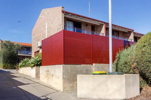a building with a red wall on a street at Sunsets on Hampton, Fremantle WA in Fremantle
