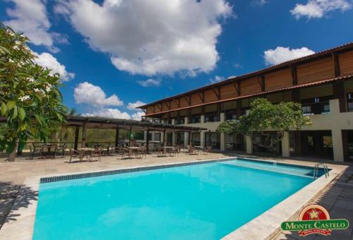 a large swimming pool in front of a hotel at Flat Fazenda Monte Castelo in Bezerros