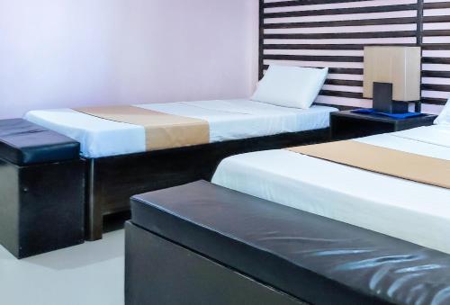 a room with three beds and a bench in it at RedDoorz at Dream Haven Bed & Breakfast in Valencia