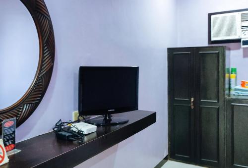 a tv sitting on a shelf in a room with a mirror at RedDoorz at Dream Haven Bed & Breakfast in Valencia