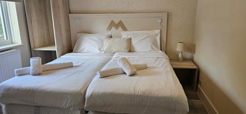 a large white bed with two books on it at MSM Arena Hotel in London