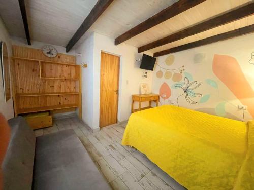 a bedroom with a yellow bed in a room at Dona Monica in Ituzaingó