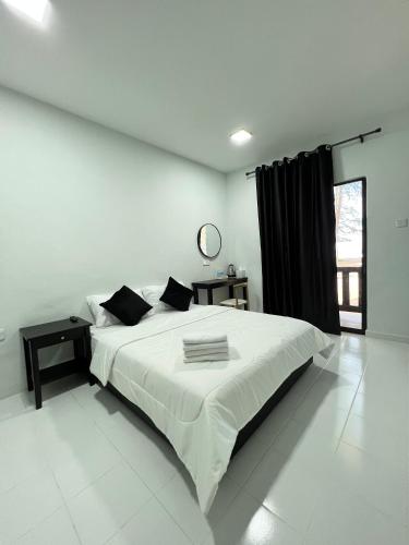 a white bedroom with a large bed in a room at Barokah Resort in Bachok