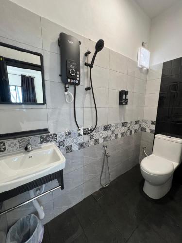 a bathroom with a shower and a toilet and a sink at Barokah Resort in Bachok