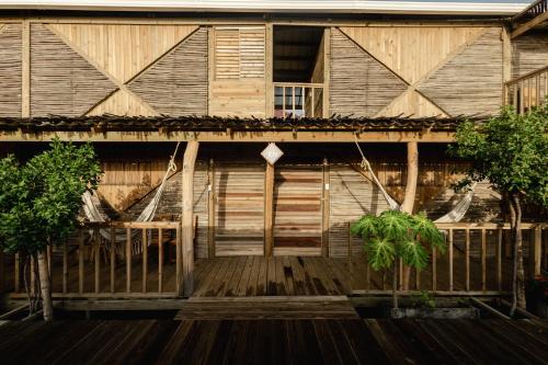a wooden building with two trees in front of it at Watu Kite House in Mayapo