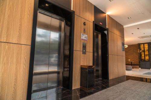 クアラ・トレンガヌにあるDJ Citi Plaza Hotel & Suitesの木造の壁の建物にあるエレベーター