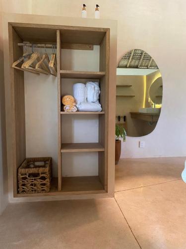 a room with a shelf with shoes and a mirror at YAM HOTEL in Mazunte