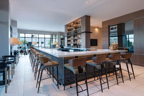 a large bar in a restaurant with stools at AC Hotel by Marriott Waco Downtown in Waco