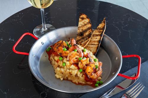 a pan of food with shrimp and bread on a table at AC Hotel by Marriott Waco Downtown in Waco
