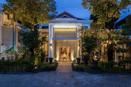 a white house with a front door with lights at YASODHARAPURA Residence in Siem Reap