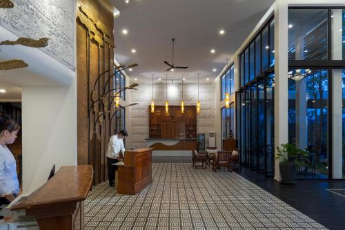 a man standing at a podium in a lobby at YASODHARAPURA Residence in Siem Reap
