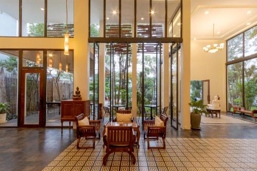 a lobby with a table and chairs and windows at YASODHARAPURA Residence in Siem Reap