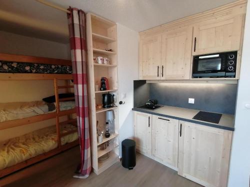 - une cuisine avec 2 lits superposés dans une chambre dans l'établissement Appartement rénové en pleine montagne avec accès direct aux pistes - FR-1-181-2829, à Aime La Plagne