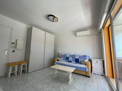 une petite chambre avec un lit et une table dans l'établissement Studio climatisé avec terrasse - Centre ville Le Lavandou - FR-1-308-201, au Lavandou